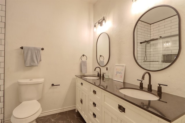 bathroom featuring toilet, tiled shower, and vanity