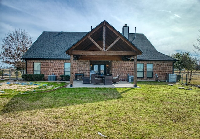 rear view of property featuring a yard, central AC, and a patio