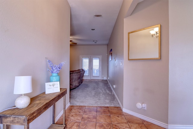 hallway featuring light colored carpet and french doors