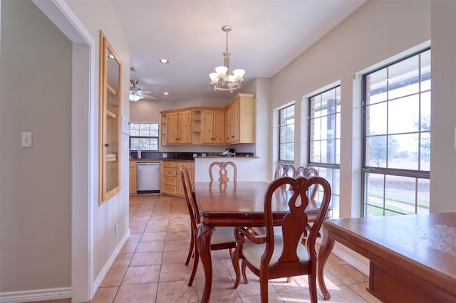 tiled dining space with ceiling fan with notable chandelier and a wealth of natural light