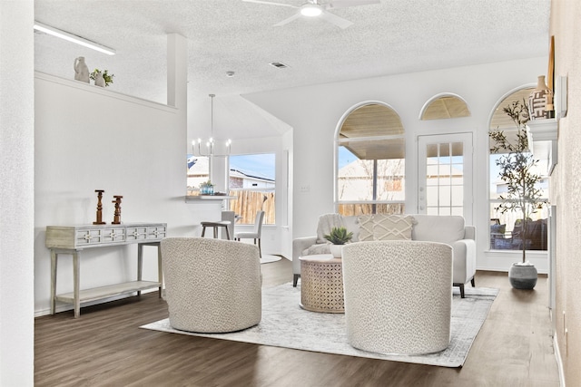 living room featuring wood-type flooring, a textured ceiling, and a wealth of natural light