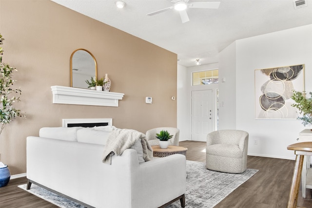 living room with ceiling fan and dark wood-type flooring