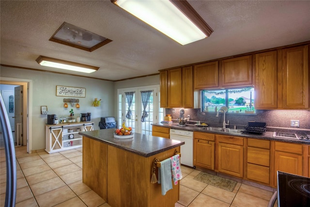 kitchen with a center island, light tile patterned floors, white dishwasher, a healthy amount of sunlight, and sink