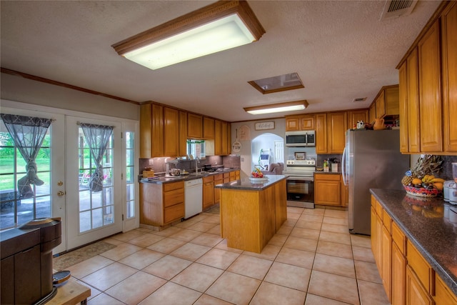 kitchen with french doors, a center island, tasteful backsplash, and appliances with stainless steel finishes