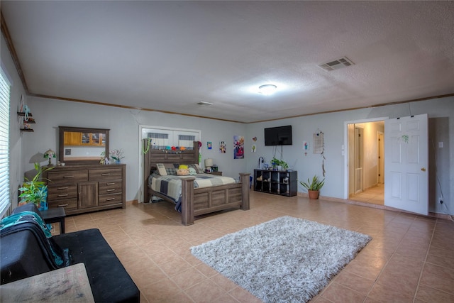 tiled bedroom featuring a textured ceiling and crown molding