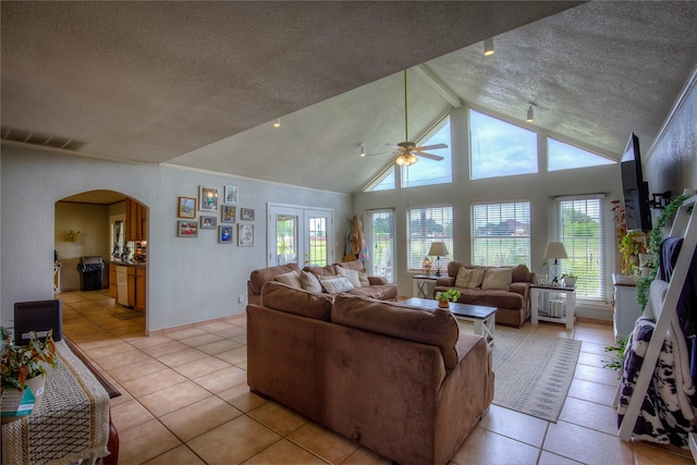 living room featuring french doors, light tile patterned flooring, a textured ceiling, and ceiling fan