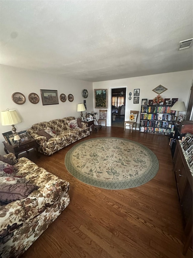 living room with dark wood-type flooring and a textured ceiling