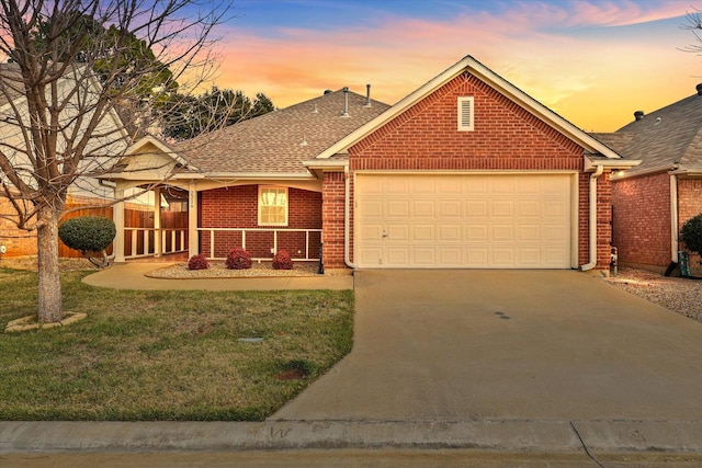 view of front of property with a porch, a lawn, and a garage