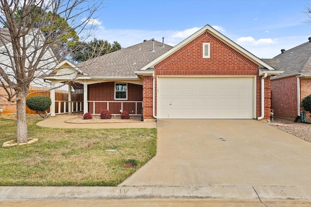 view of front of house with roof with shingles, concrete driveway, a front yard, a garage, and brick siding