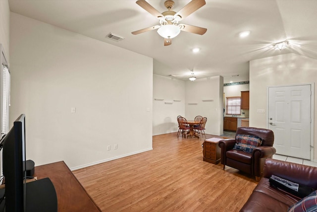 living room with ceiling fan and light hardwood / wood-style flooring