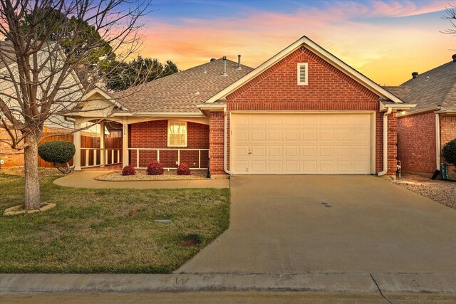 view of front of house featuring a porch, a lawn, and a garage