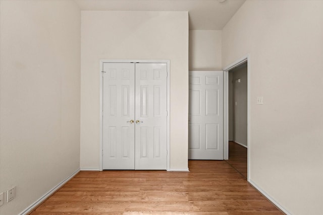 unfurnished bedroom featuring light wood-type flooring and a closet