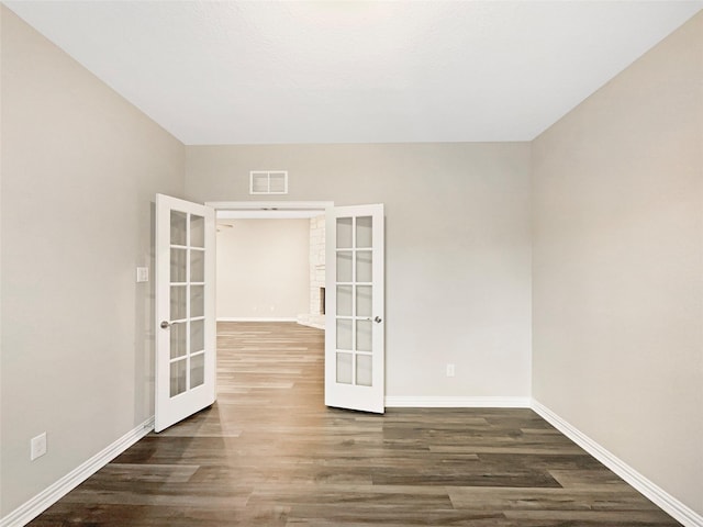 spare room with dark wood-type flooring and french doors