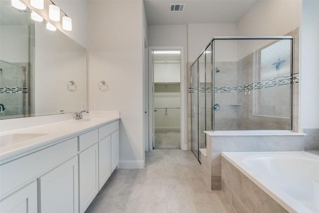 bathroom with tile patterned flooring, shower with separate bathtub, and vanity