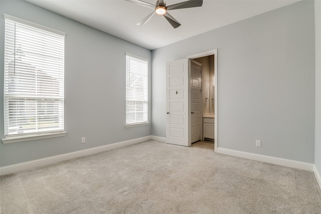 unfurnished bedroom with light colored carpet, ceiling fan, and connected bathroom