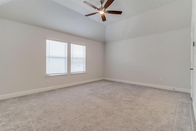 unfurnished room with light colored carpet, ceiling fan, and vaulted ceiling