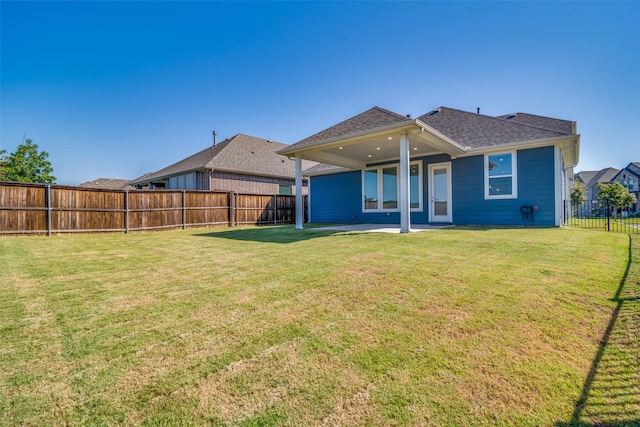 rear view of property featuring a patio area and a yard