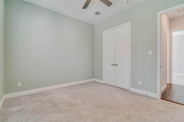 unfurnished bedroom featuring a closet, ceiling fan, and light colored carpet