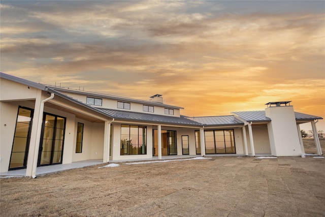 back house at dusk with a patio