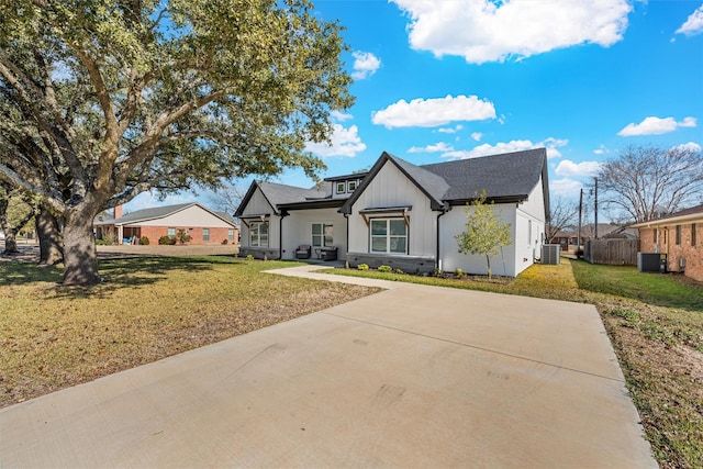 view of front of home with a front lawn and central AC unit