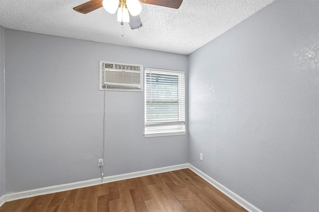 spare room with an AC wall unit, a textured ceiling, hardwood / wood-style floors, and ceiling fan