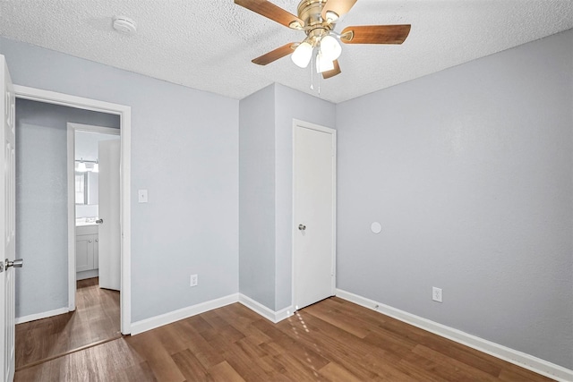 unfurnished bedroom featuring hardwood / wood-style floors, a textured ceiling, and ceiling fan