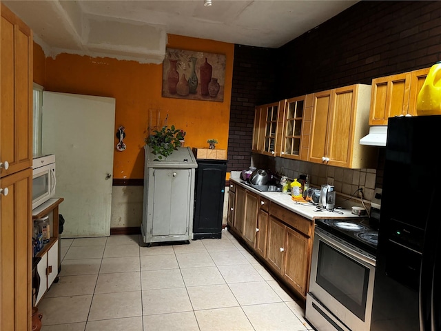 kitchen featuring light tile patterned floors, tasteful backsplash, black refrigerator with ice dispenser, electric range, and sink