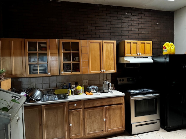 kitchen with black refrigerator, backsplash, light tile patterned floors, and stainless steel electric range oven