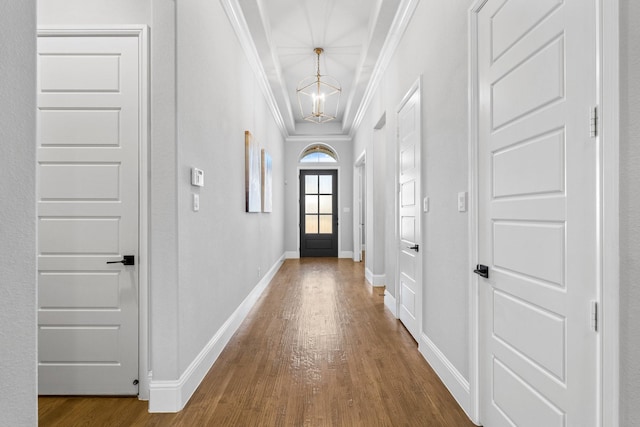 entryway featuring an inviting chandelier, ornamental molding, and hardwood / wood-style flooring