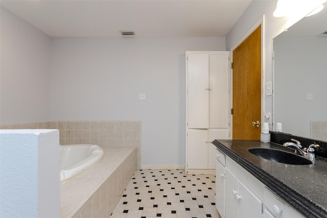 bathroom featuring vanity and tiled bath