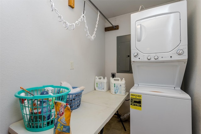 laundry area with electric panel and stacked washer / drying machine