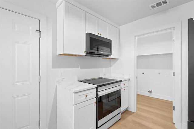 kitchen with stainless steel appliances, light hardwood / wood-style floors, white cabinets, and light stone countertops