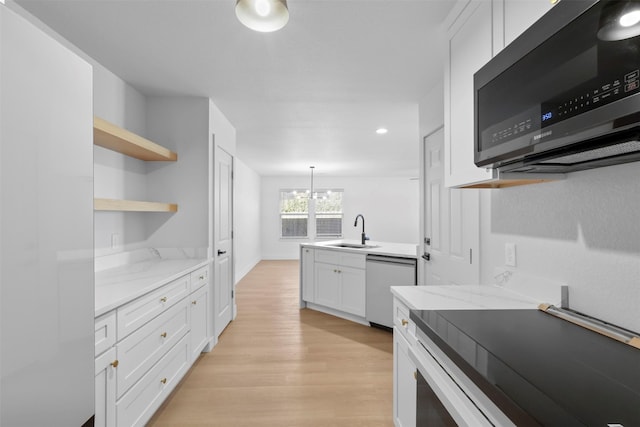 kitchen featuring light stone countertops, stainless steel dishwasher, a chandelier, white cabinetry, and sink