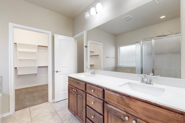 bathroom with an enclosed shower, vanity, and tile patterned floors