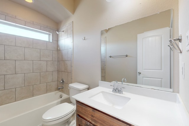 full bathroom featuring tiled shower / bath, vanity, and toilet