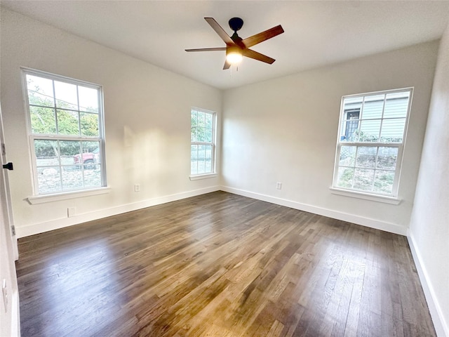 unfurnished room featuring ceiling fan, dark hardwood / wood-style floors, and plenty of natural light