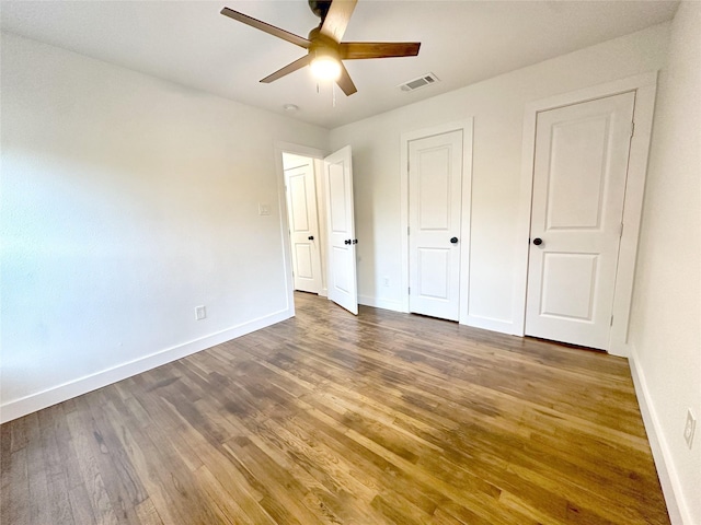 unfurnished bedroom with ceiling fan and dark hardwood / wood-style floors