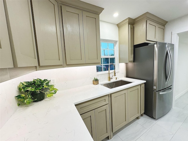 kitchen with decorative backsplash, stainless steel fridge, and sink