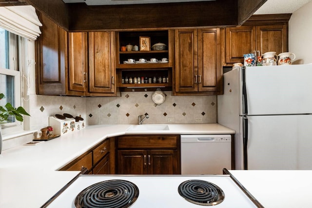 kitchen with white appliances, backsplash, and sink