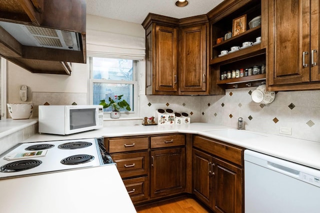 kitchen with sink, white appliances, tasteful backsplash, light hardwood / wood-style floors, and range hood