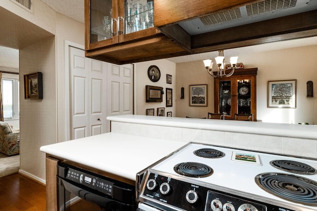 kitchen featuring dark wood-type flooring, electric stove, exhaust hood, an inviting chandelier, and black dishwasher