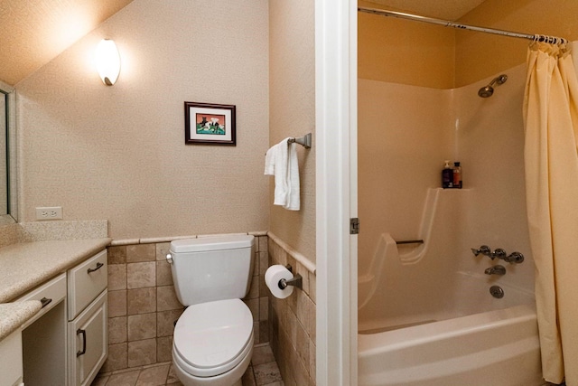 full bathroom featuring shower / tub combo, tile patterned flooring, toilet, vanity, and tile walls