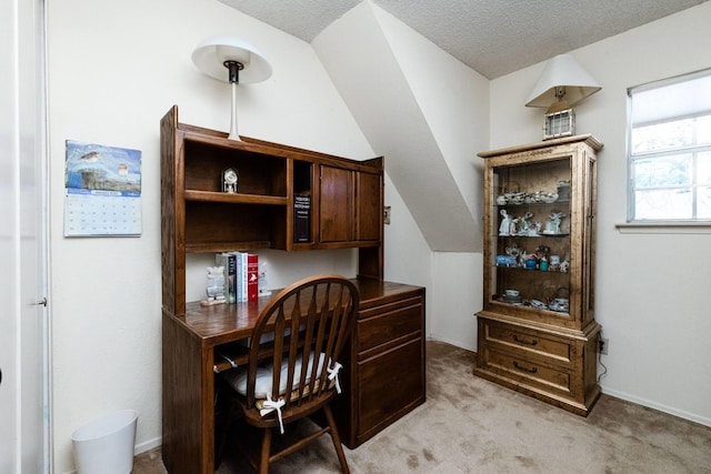 carpeted home office featuring a textured ceiling