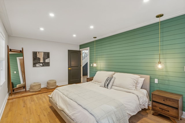 bedroom with ornamental molding and light hardwood / wood-style floors