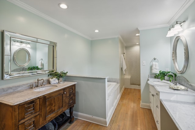 bathroom featuring hardwood / wood-style flooring, plus walk in shower, crown molding, and vanity