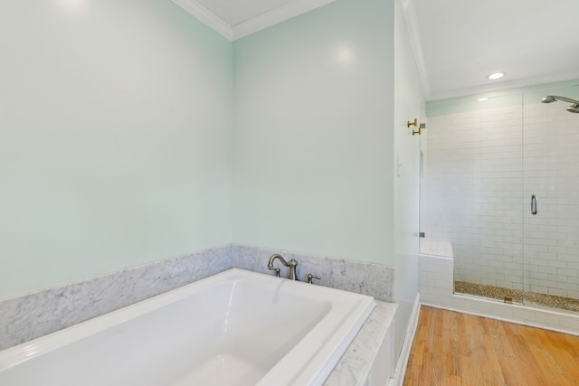 bathroom featuring ornamental molding, hardwood / wood-style flooring, and separate shower and tub