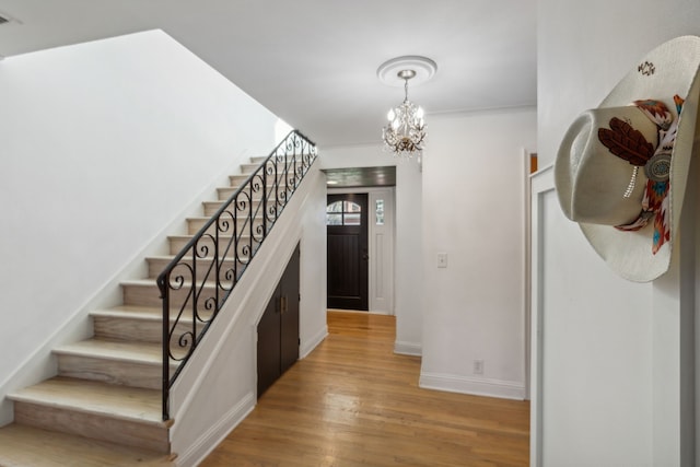 stairway with a notable chandelier and hardwood / wood-style floors