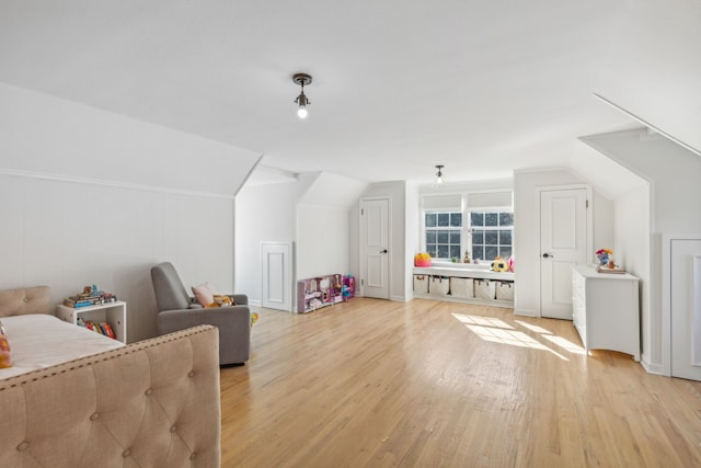 additional living space featuring lofted ceiling and light wood-type flooring