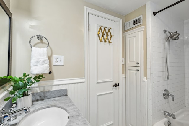 bathroom featuring vanity and tiled shower / bath