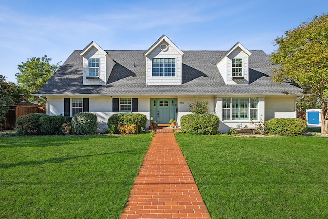 cape cod house featuring a front yard